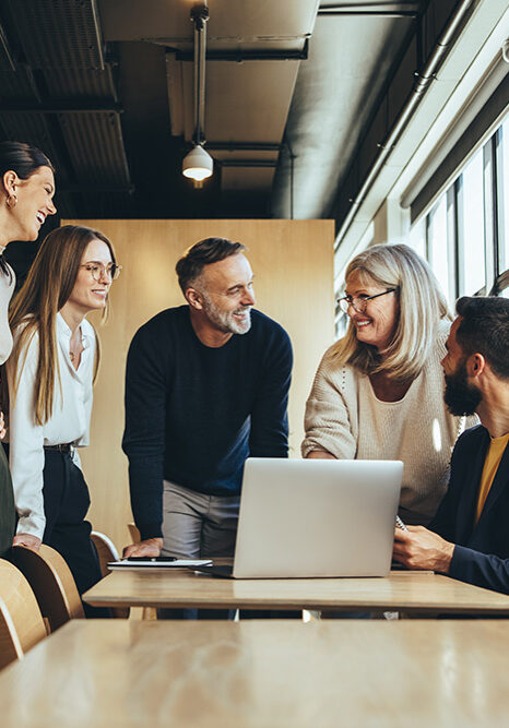 AdobeStock_509990675 Smiling businesspeople having a discussion in an office